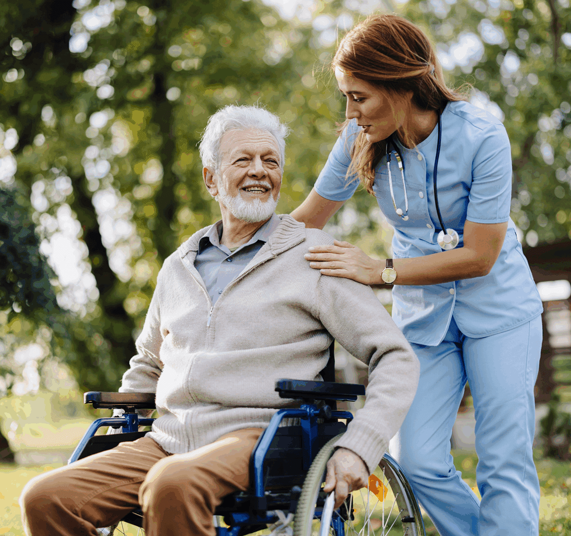 Nurse assisting elderly man in wheelchair outdoors.
